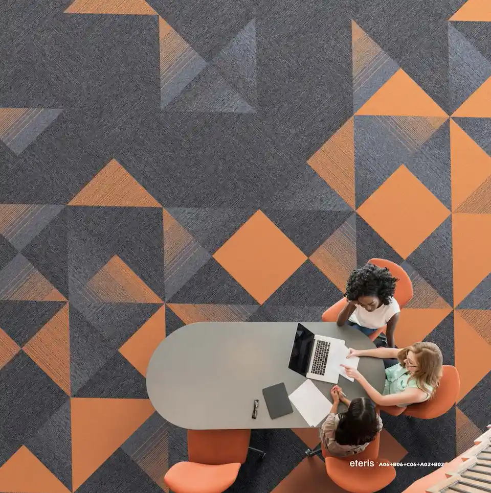 carpete modular nylon eteris amba floors em composição geométrica cinza e laranja em sala de reunião corporativa